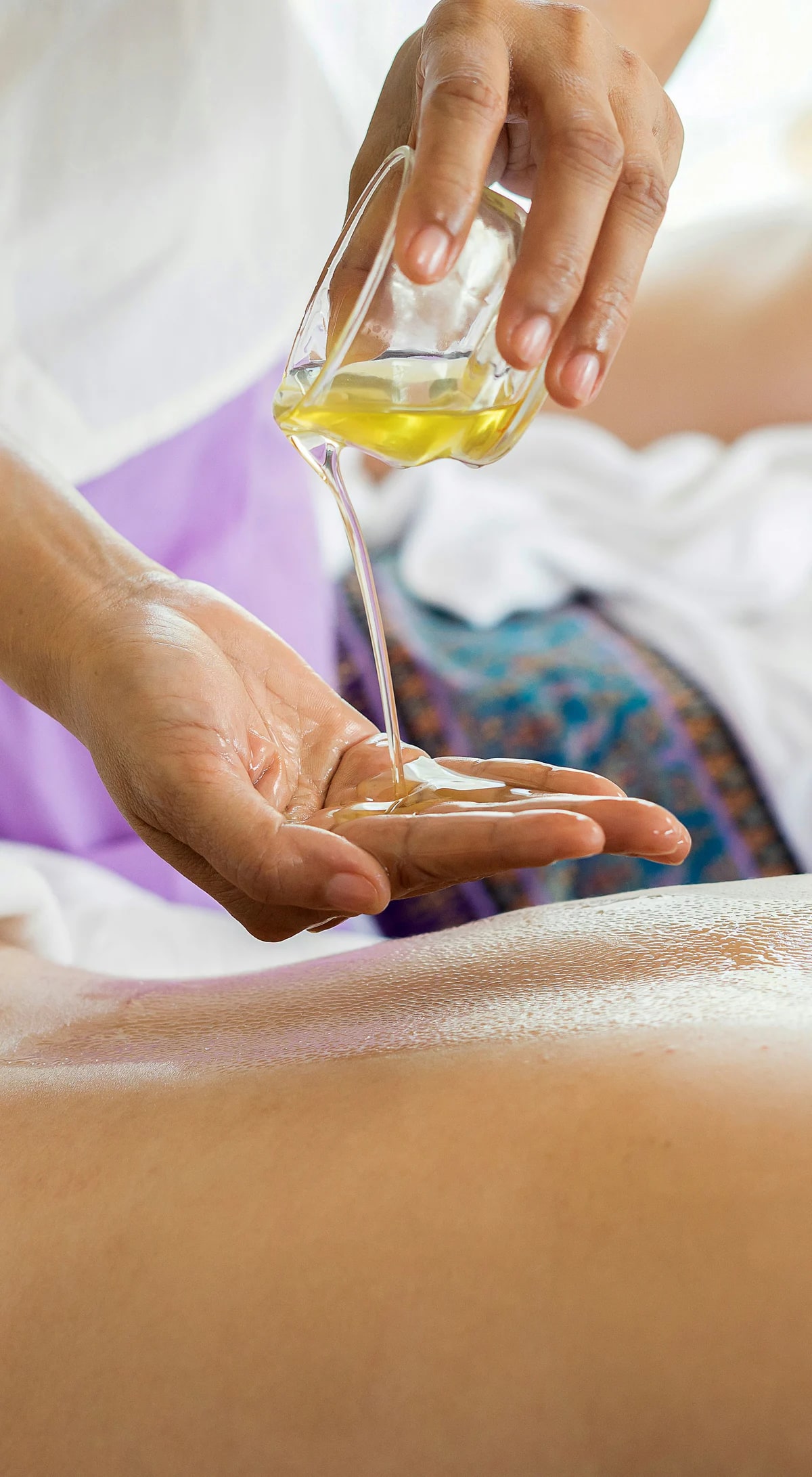Una terapeuta vierte aceite para un masaje